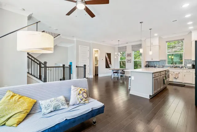 a living room with kitchen island granite countertop wooden floor furniture and a kitchen view
