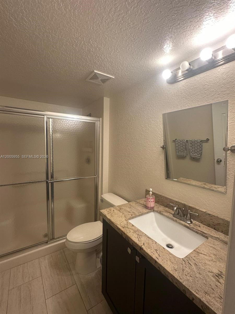 6920 West Sample Road, Unit 6920 Pompano Beach, FL 33063 - Photo 11 of 30 a bathroom with a granite countertop sink toilet and shower
