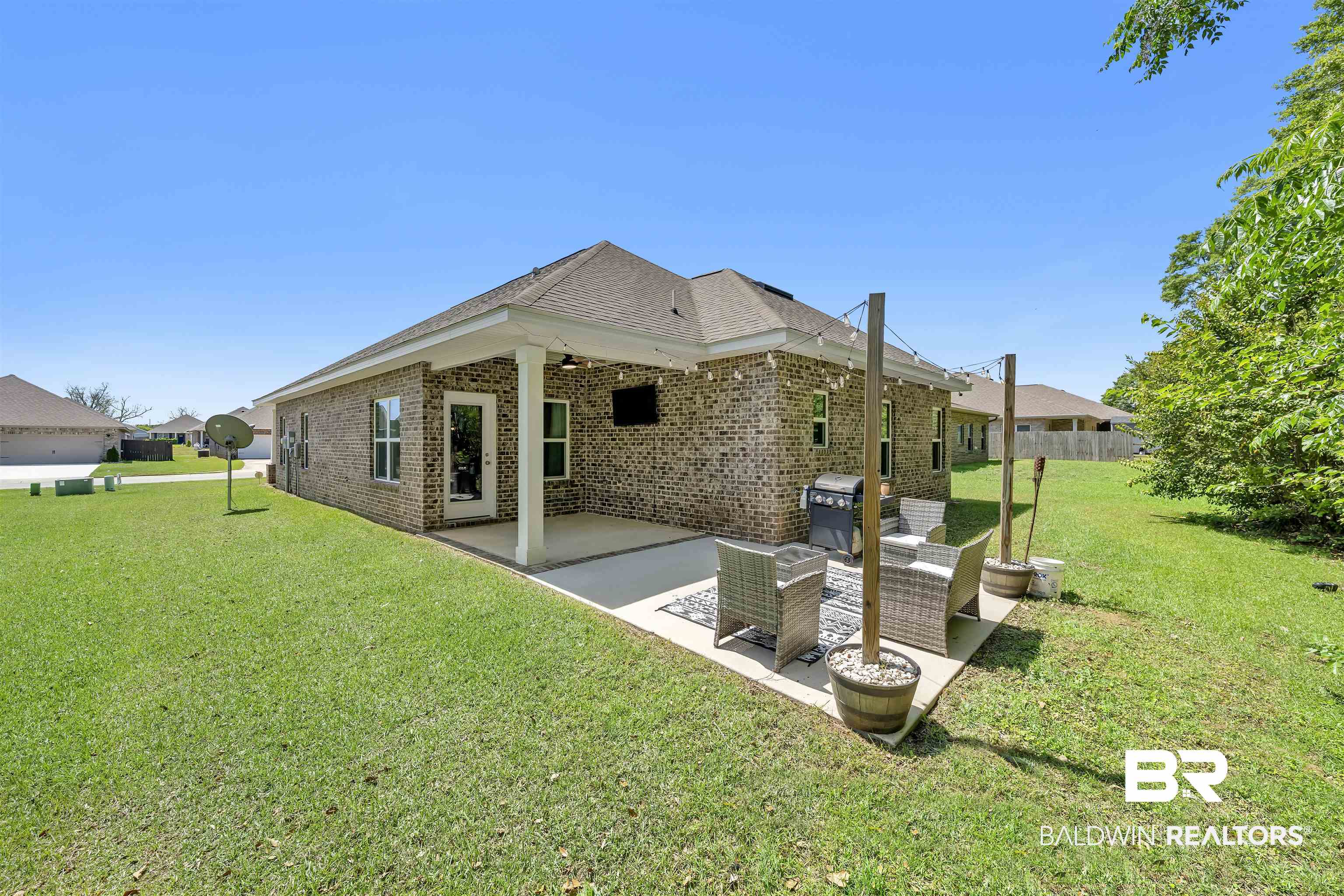 16504 Prado Loop Loxley, AL 36551 - Photo 35 of 45 Back of property with a patio area, brick siding, a yard, and a shingled roof