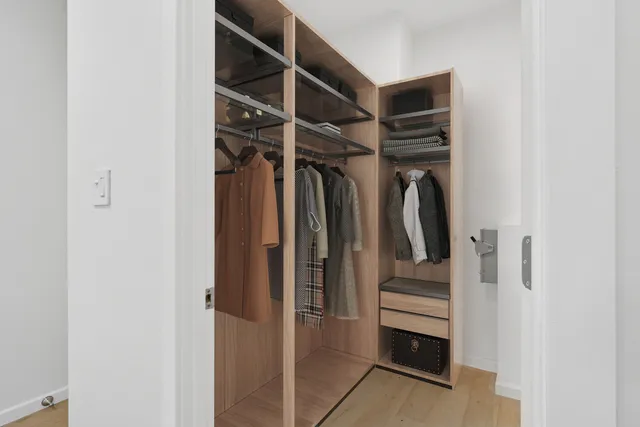 a bedroom with a bed and a flat tv screen on a dresser