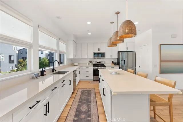 a large kitchen with stainless steel appliances kitchen island granite countertop a sink and cabinets