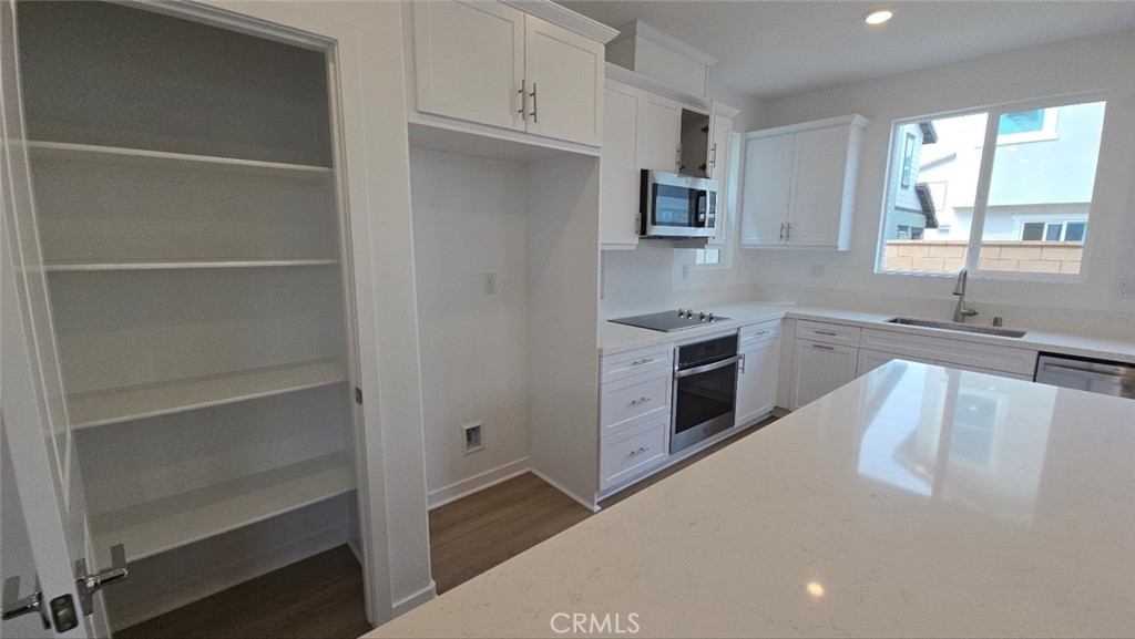 3256 Sprout Paseo Ontario, CA 91761 - Photo 12 of 44 a large white kitchen with cabinets