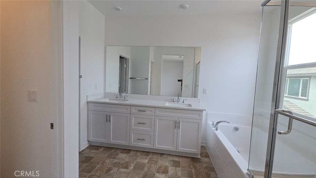 3256 Sprout Paseo Ontario, CA 91761 - Photo 22 of 44 a spacious bathroom with a double vanity sink a mirror and a bathtub