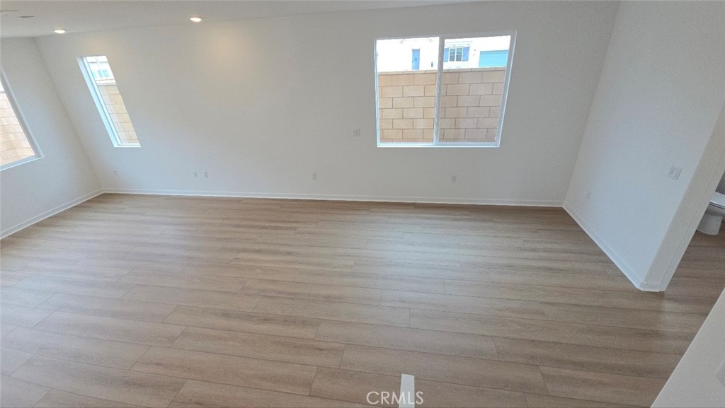 3256 Sprout Paseo Ontario, CA 91761 - Photo 33 of 44 an empty room with wooden floor and windows