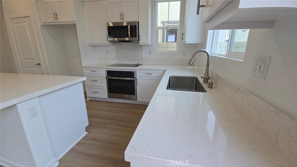 3256 Sprout Paseo Ontario, CA 91761 - Photo 6 of 44 a kitchen with a sink a stove and microwave