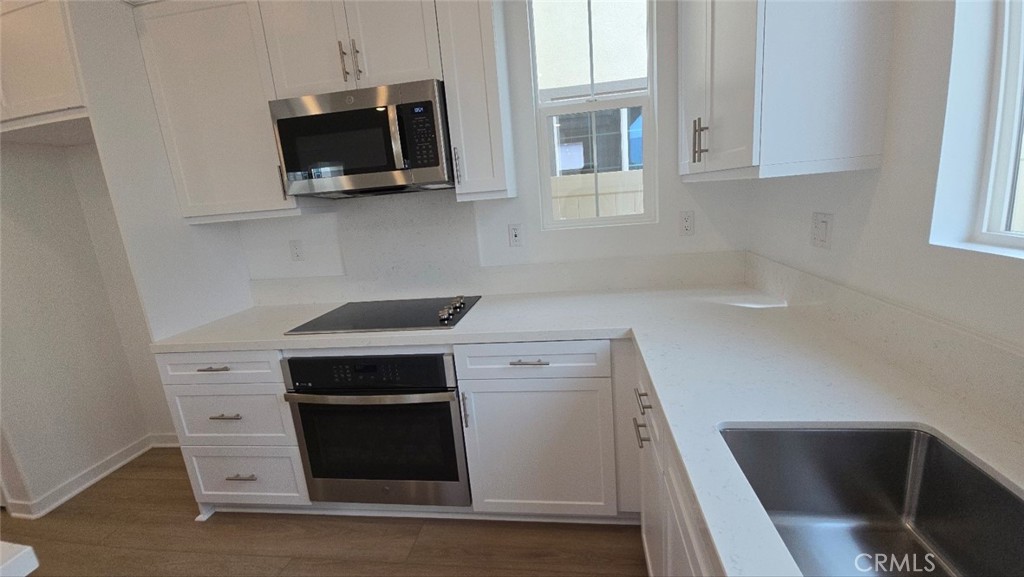 3256 Sprout Paseo Ontario, CA 91761 - Photo 8 of 44 a kitchen with stainless steel appliances a stove microwave and sink