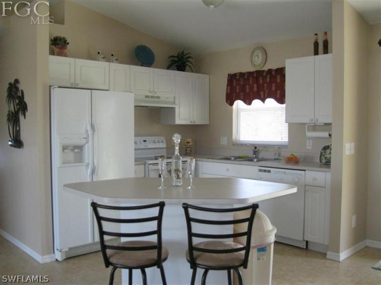 245 Rue Labonne Road Fort Myers, FL 33913 - Photo 3 of 18 a kitchen with a dining table chairs and window