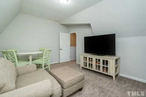 a bedroom with a bed a chandelier and a chair