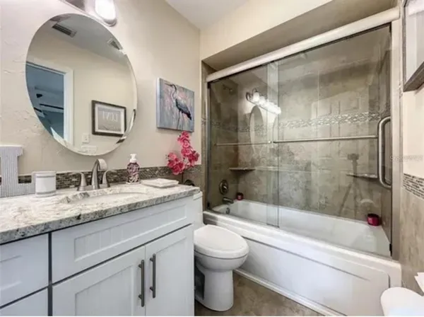 a bathroom with a granite countertop sink toilet and shower