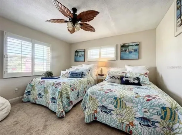 a bedroom with two beds and a chandelier
