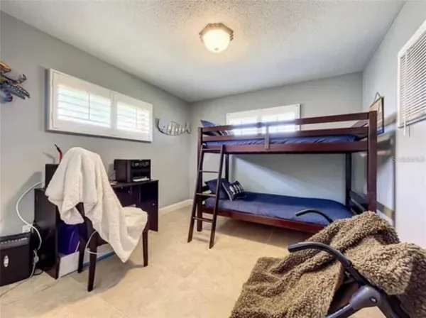 a bedroom with two bunk beds and a desk