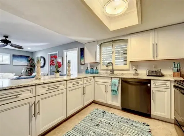 a kitchen with granite countertop white cabinets and white appliances