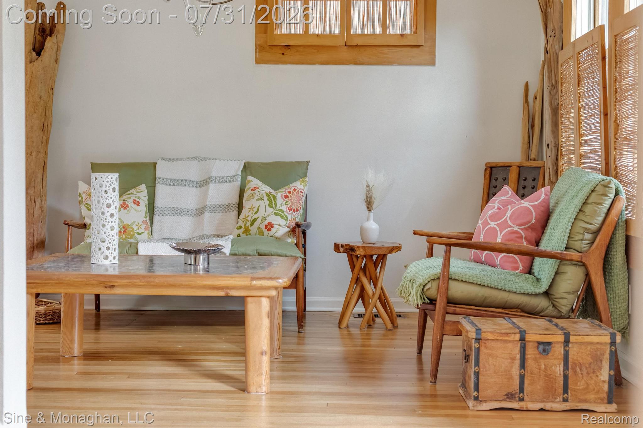 Hardwood flooring with a natural finish, light-toned walls, and a window with wooden framing