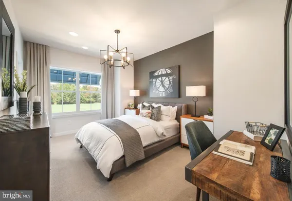 a spacious bedroom with a bed and a chandelier