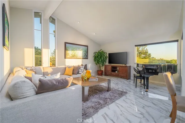a living room with furniture kitchen view and a large window