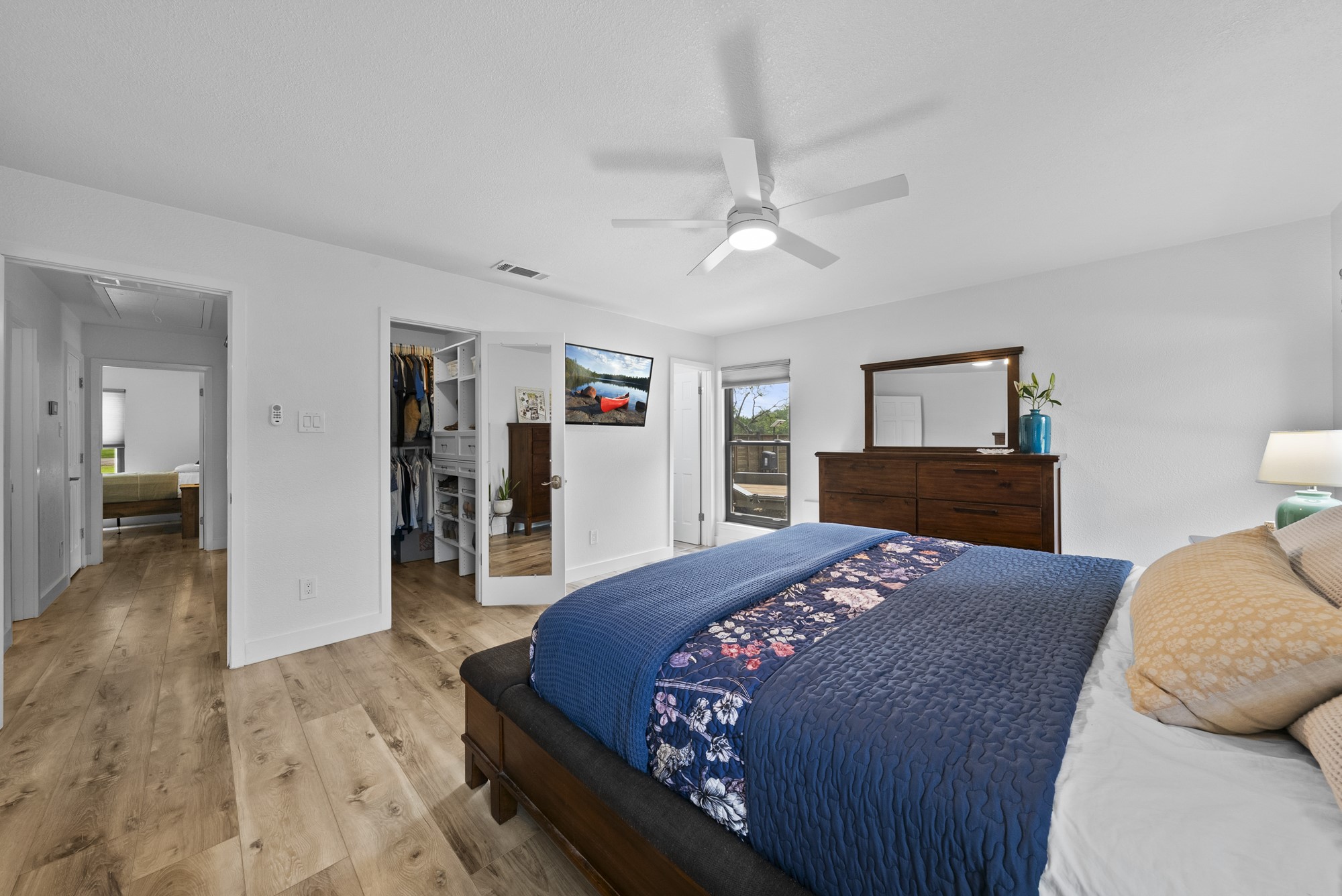 2802 Robin Road Manchaca, TX 78652 - Photo 32 of 40 Spacious bedroom featuring wood-finish flooring, a contemporary ceiling fan with integrated lighting, and white walls