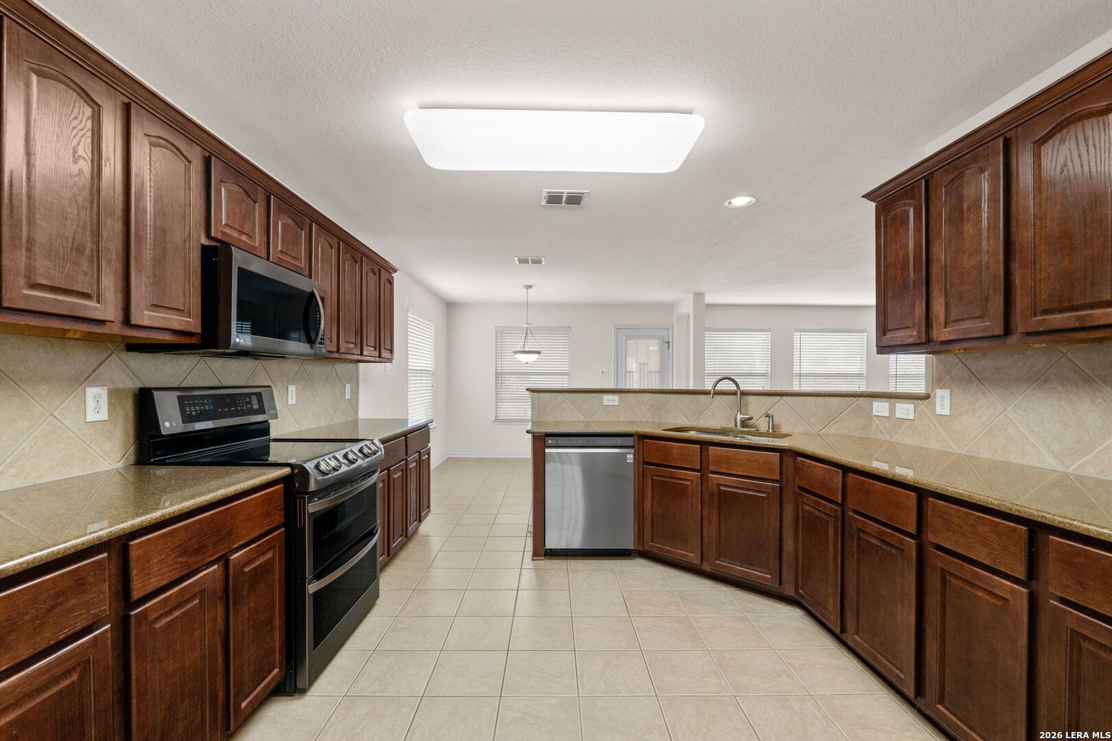 9727 Krier Court Converse, TX 78109 - Photo 2 of 31 a large kitchen with stainless steel appliances granite countertop wooden cabinets a stove a sink and a microwave