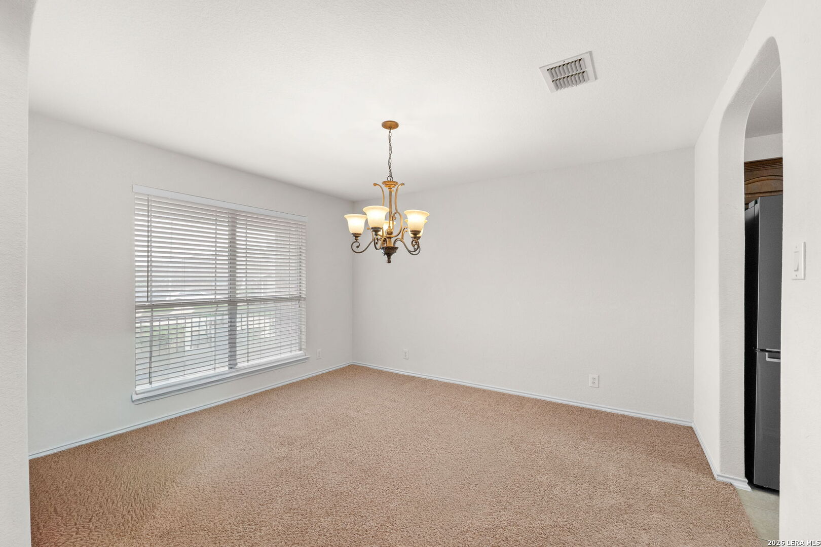 9727 Krier Court Converse, TX 78109 - Photo 6 of 31 an empty room with chandelier windows and chandelier