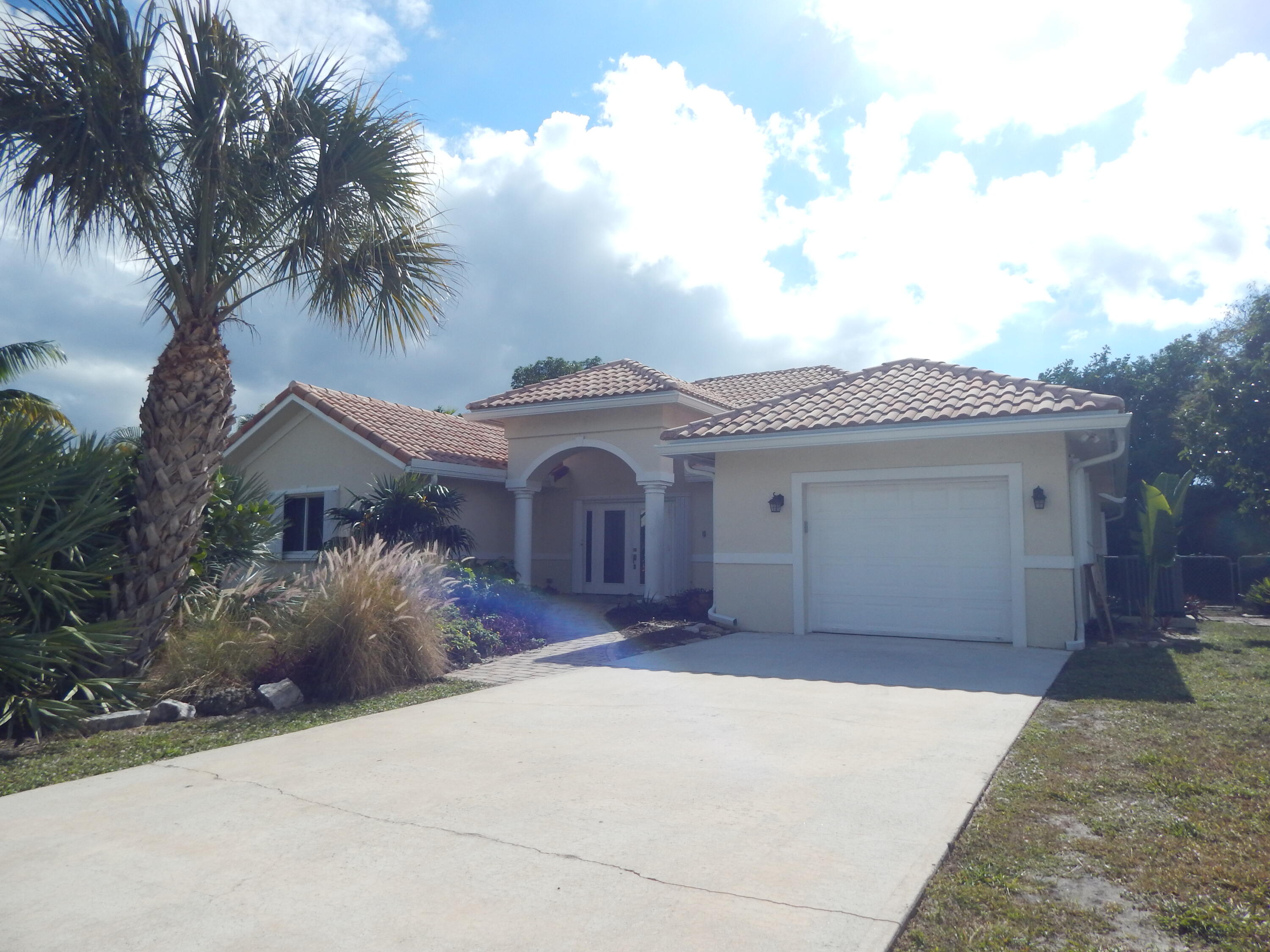 298 Northwest 11th Street Boca Raton, FL 33432 - Photo 1 of 3 front view of a house with a yard and palm trees
