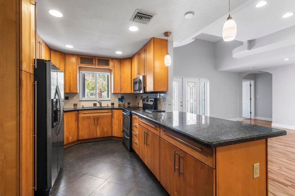298 Northwest 11th Street Boca Raton, FL 33432 - Photo 2 of 19 a kitchen with stainless steel appliances granite countertop a sink a stove and refrigerator