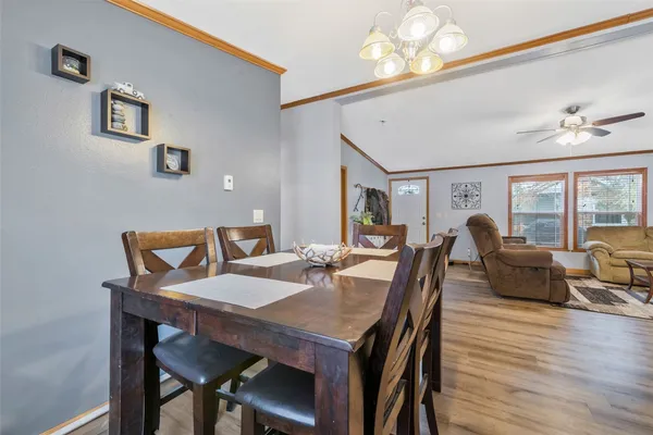 a view of a dining room with furniture a chandelier and wooden floor