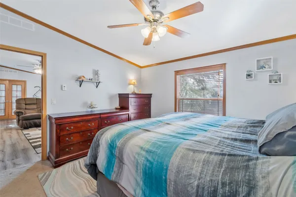 a bedroom with a bed and a dresser with mirror