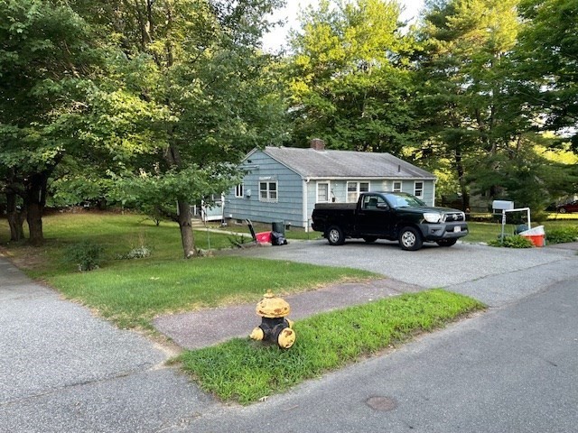 28 Martin Road Reading, MA 01867 - Photo 15 of 19 a car parked in front of a house next to a yard