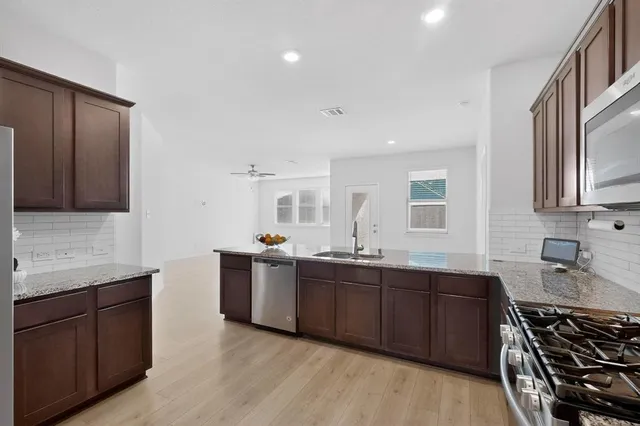 a kitchen with stainless steel appliances granite countertop wooden cabinets a sink and dishwasher