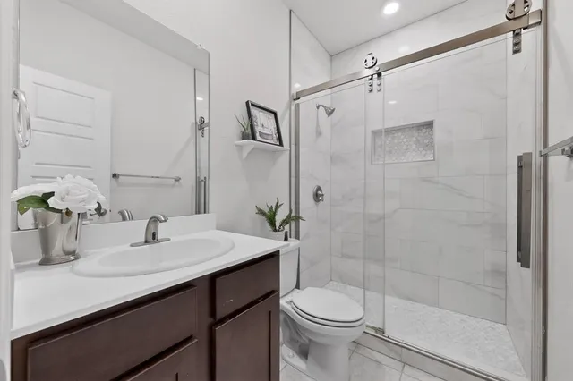 a bathroom with a sink a toilet and shower