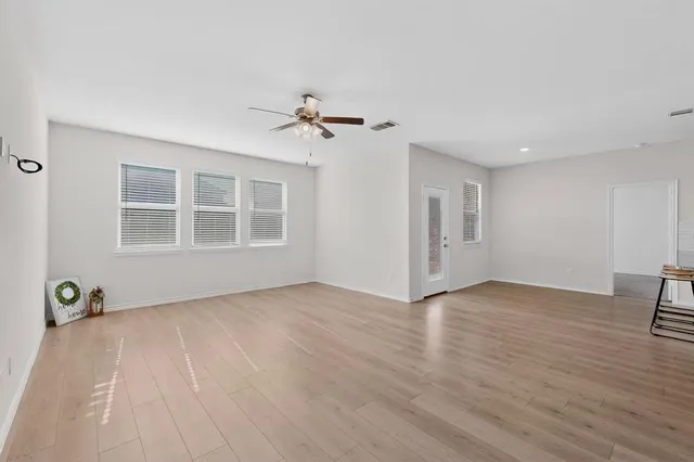 a view of empty room with a window and wooden floor