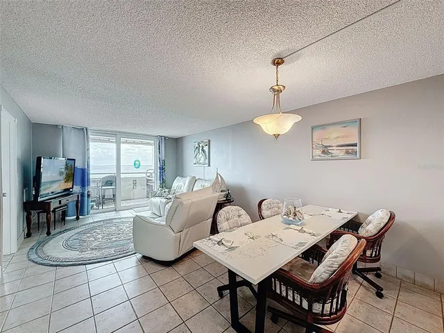 a bedroom with a bed a flat screen tv and a chandelier