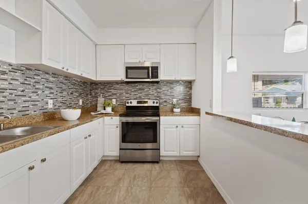 a kitchen with granite countertop white cabinets and white appliances