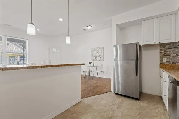 a view of a kitchen with a refrigerator and a more cabinets