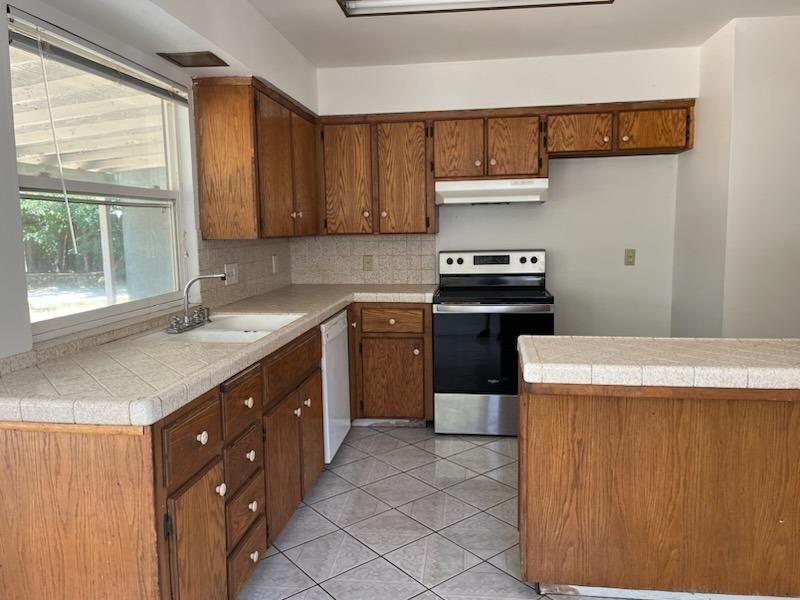 3065 Anderson Avenue Clovis, CA 93612 - Photo 3 of 16 a kitchen with a sink stove and cabinets