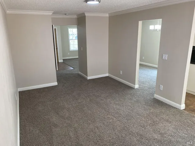 an empty room with windows and entrance to other room