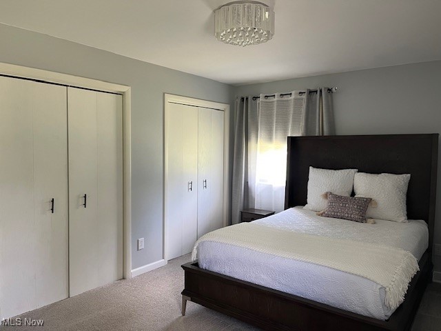 5795 Merwin Chase Road Brookfield, OH 44403 - Photo 22 of 39 Bedroom with two closets, carpet flooring, and a chandelier