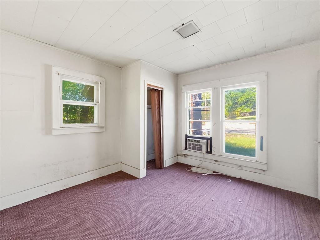 908 South Rice Street Hamilton, TX 76531 - Photo 12 of 13 an empty room with wooden floor and windows