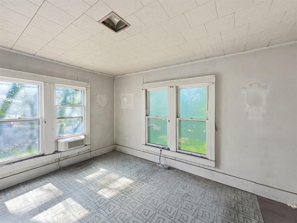 908 South Rice Street Hamilton, TX 76531 - Photo 8 of 13 a view of an empty room with wooden floor and a window