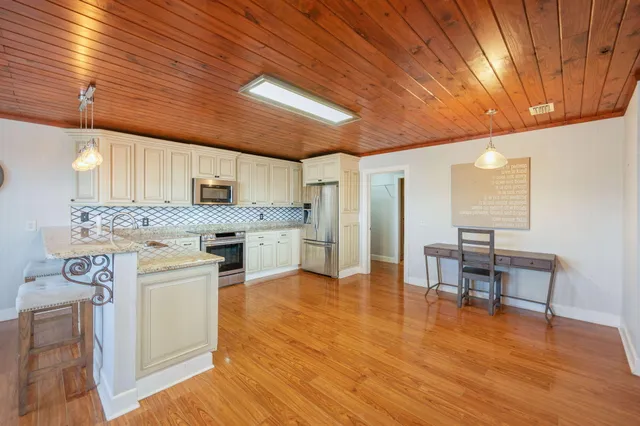 a kitchen with a sink cabinets and wooden floor