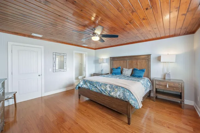 a spacious bedroom with a large bed and a chandelier