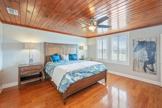 a spacious bedroom with a bed and a flat screen tv