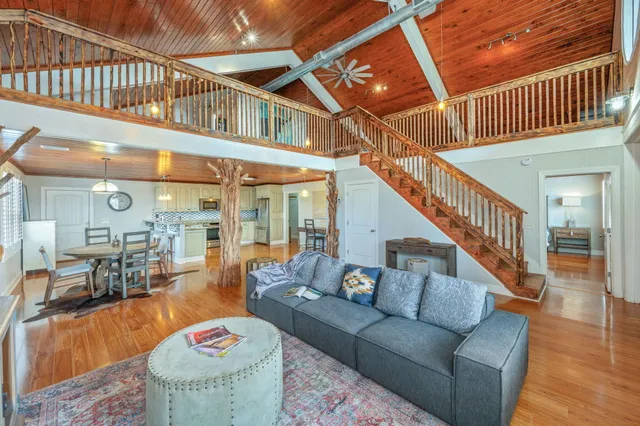 a large kitchen with cabinets chairs and wooden floor