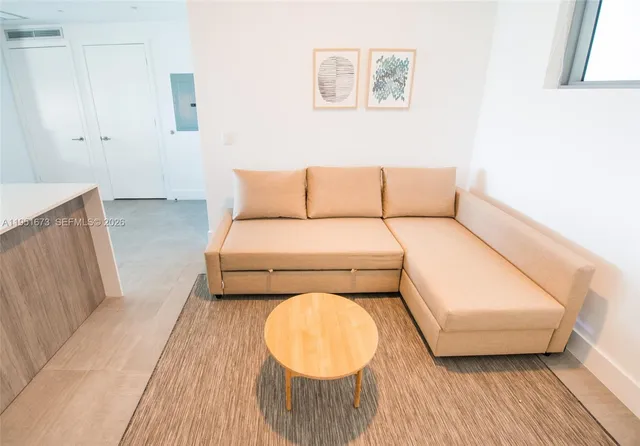 a living room with furniture and a floor to ceiling window