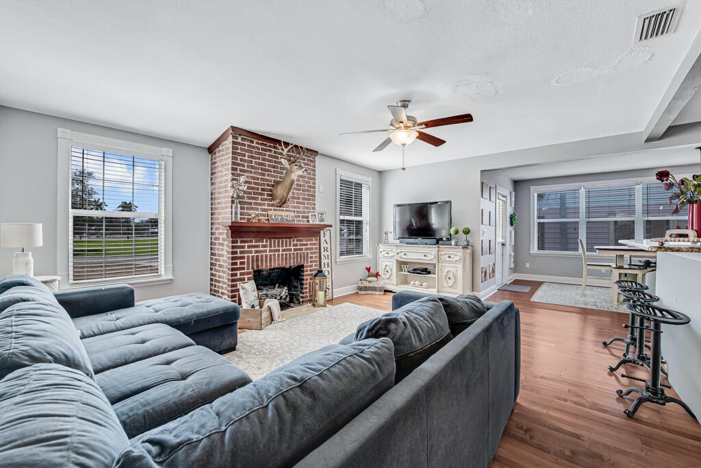 416 Deane Duff Street Clewiston, FL 33440 - Photo 12 of 45 a living room with furniture a fireplace and a flat screen tv