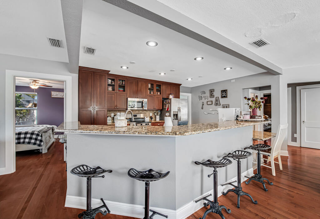416 Deane Duff Street Clewiston, FL 33440 - Photo 5 of 45 a kitchen with stainless steel appliances a dining table chairs and wooden floor