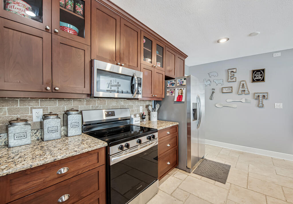 416 Deane Duff Street Clewiston, FL 33440 - Photo 6 of 45 a kitchen with stainless steel appliances granite countertop a stove and a microwave