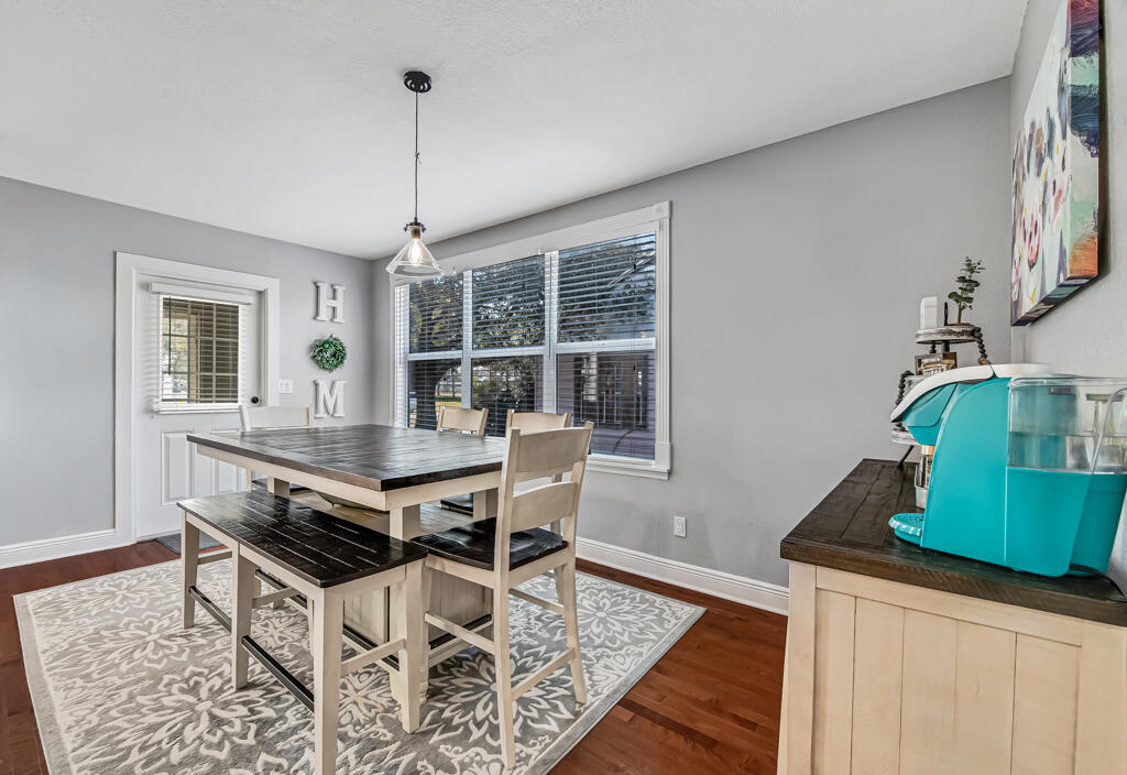 416 Deane Duff Street Clewiston, FL 33440 - Photo 9 of 45 a dining room with wooden floor a chandelier a wooden table and chairs
