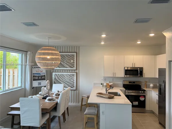 a kitchen with a sink appliances and chairs