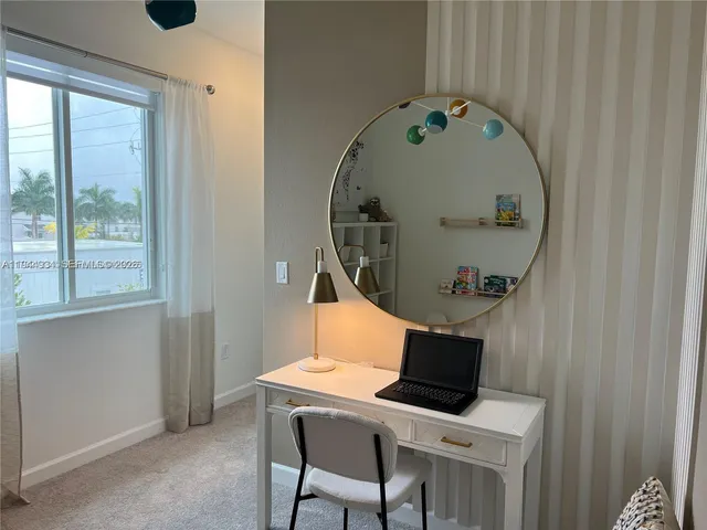 a view of a dining room with furniture and a window