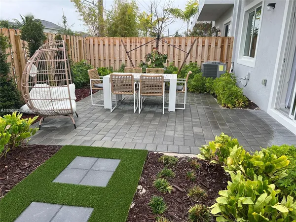 a view of a chair and table in backyard of the house